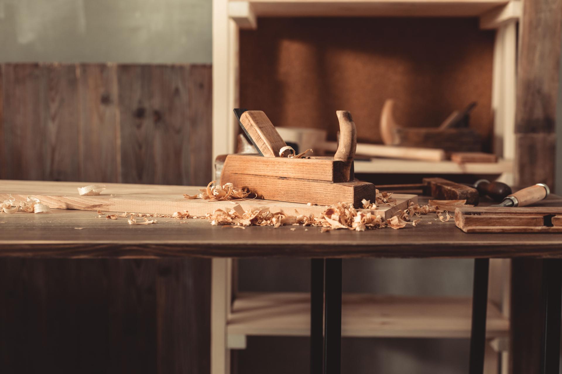 Plane jointer carpenter or joiner tool and wood shavings. Woodworking tools at wooden table. Carpentry workshop